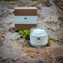 Load image into Gallery viewer, a glass jar of unscented hand cream sits on a boulder with it's black metal cap removed to show the creamy  lotion inside