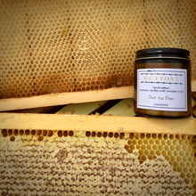 Load image into Gallery viewer, unscented beeswax candle sits on beehive frame