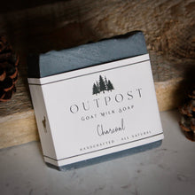 Load image into Gallery viewer, close up of activated charcoal soap with OUTPOST pine tree label