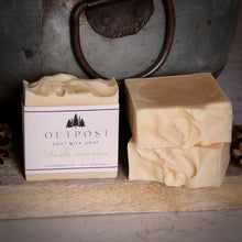 Load image into Gallery viewer, cream colored bar of goat milk soap with  OUTPOST pine tree label